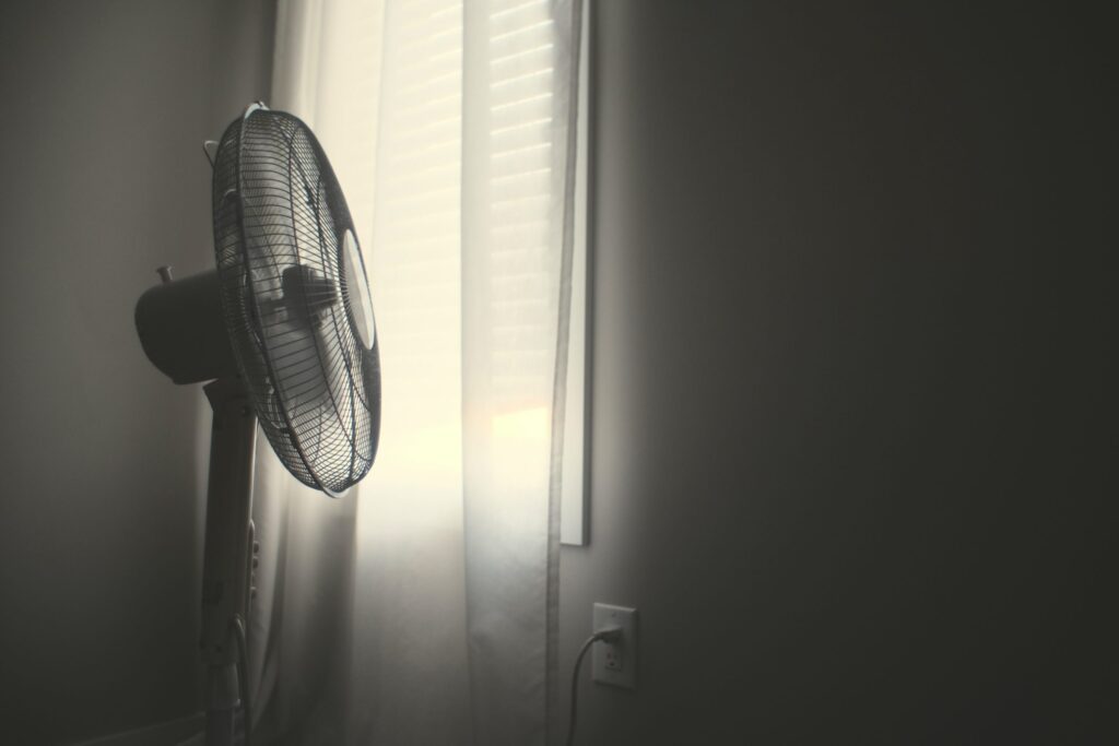 pedestal fan blowing a long curtain