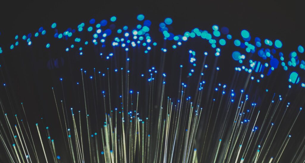 the frayed ends of a fibre optic cable illuminated in blue