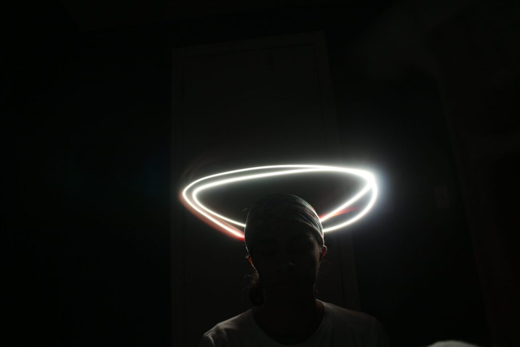 a shadowed figure, encircled by a halo of light