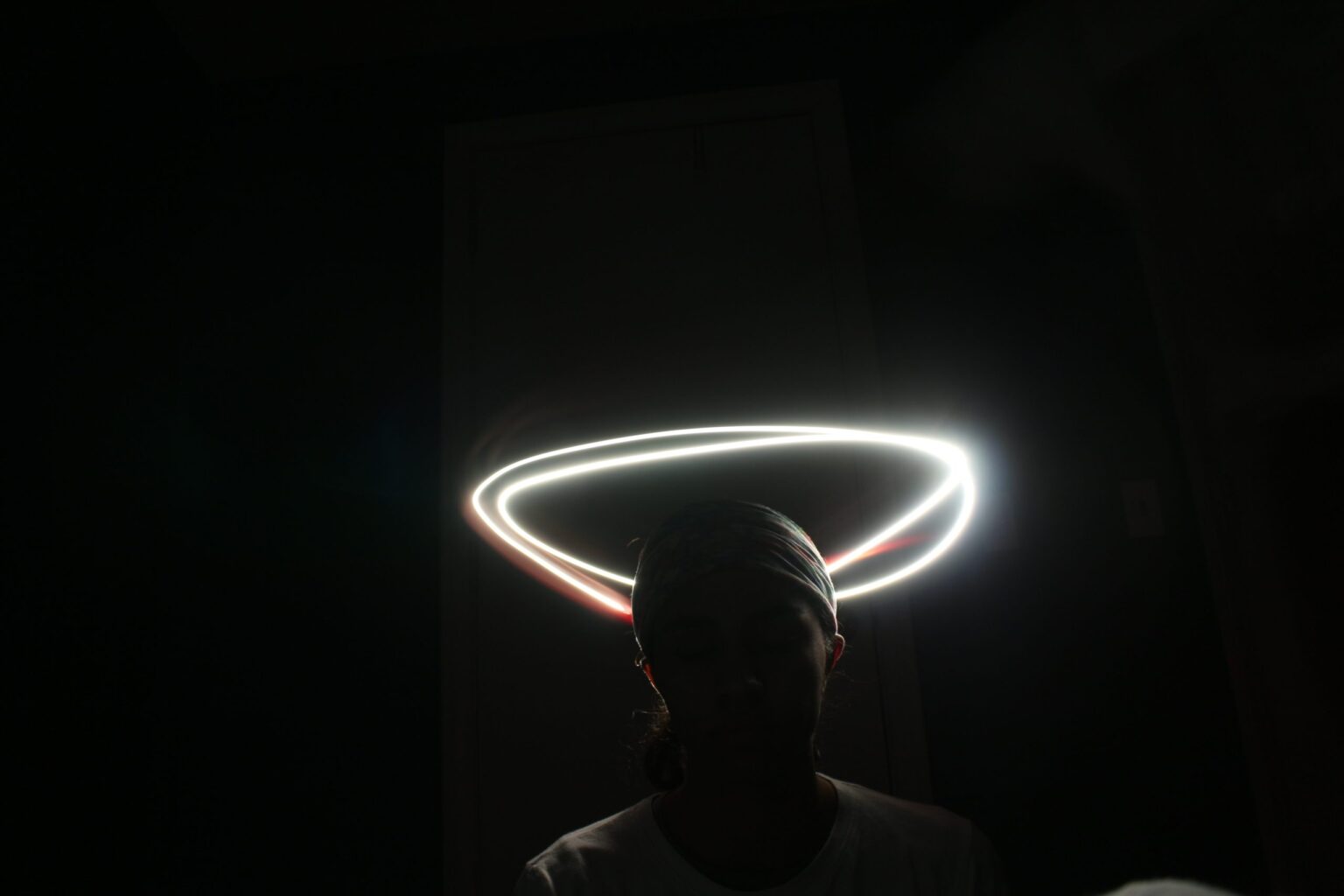 a shadowed figure, encircled by a halo of light