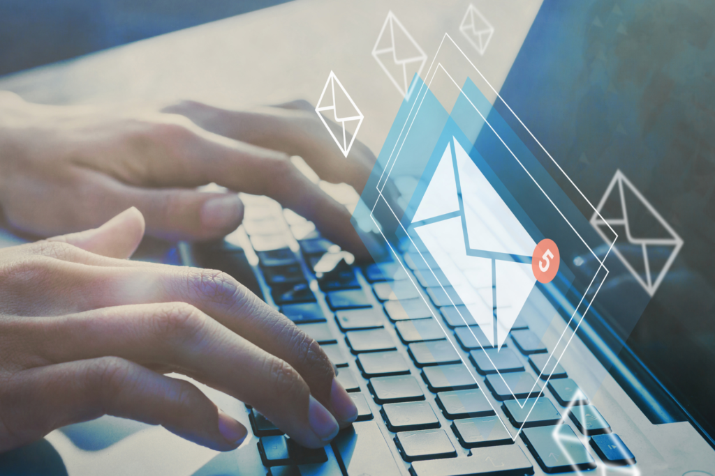 hands typing on a laptop keyboard with a floating graphic of an email icon and notification bubble