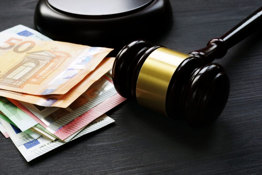 a judges gavel is pictured next to a pile of euros